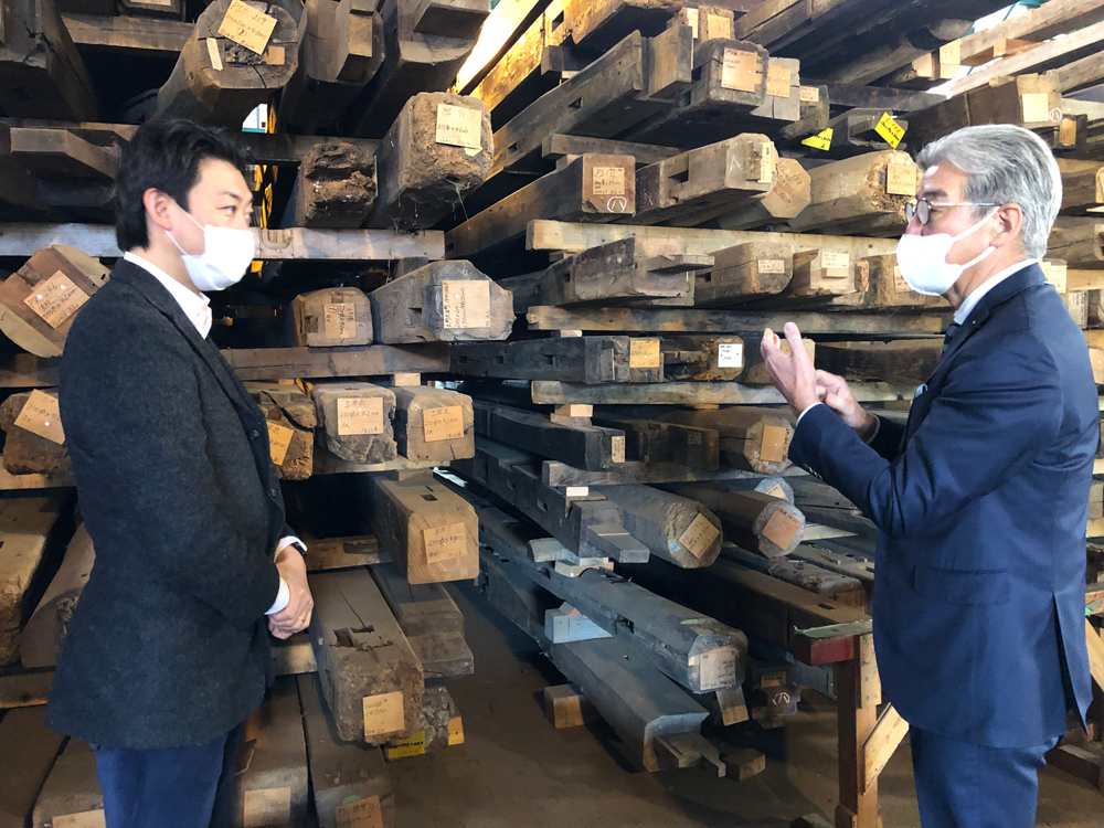 山翠舎の古木専門倉庫の視察風景（左：山翠舎代表取締役社長山上氏、右：丹青社代表取締役社長小林）